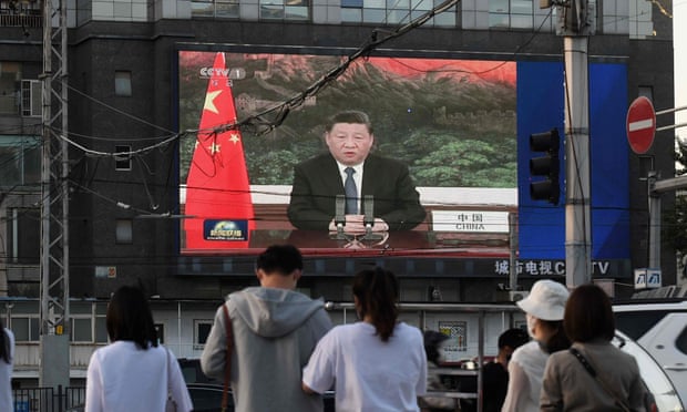 People in Beijing watch President Xi Jinping speaking to the World Health Assembly via videolink.