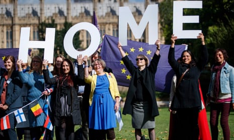 People smiling, holding EU flags and letters spelling ‘home’.