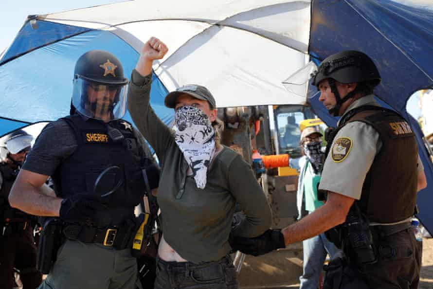 A demonstrator is detained as people protest against the Line 3 pipeline by occupying an Enbridge pump station construction site in Park Rapids, Minnesota.