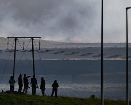 Tourists watch the eruption from a road near Keflavík airport