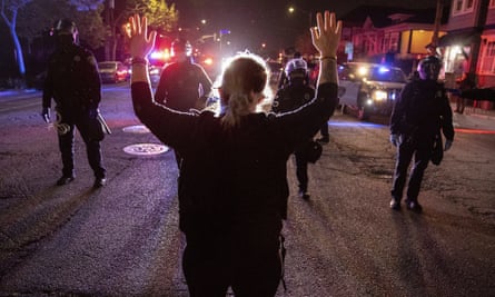 A demonstrator confronts a line of police officers in Oakland, California, on 16 April.
