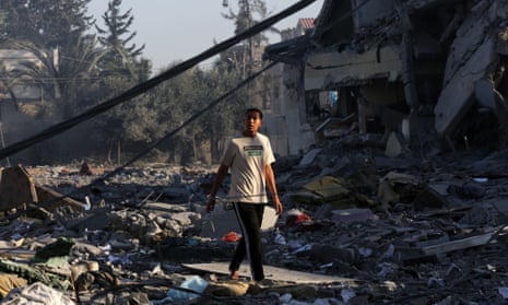 A young man is seen among the rubble of a building destroyed in Israeli airstrikes in the central Gaza Strip city of al-Zahra