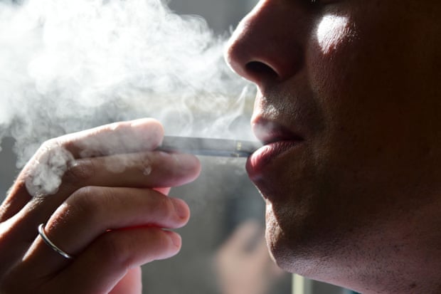 A man exhales smoke from an electronic cigarette.