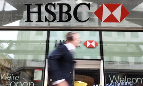 A pedestrian walking past a HSBC bank branch in London