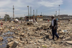 Martin Muiruri, at the spot where his small grocery shop used to be, in front of a partially demolished school
