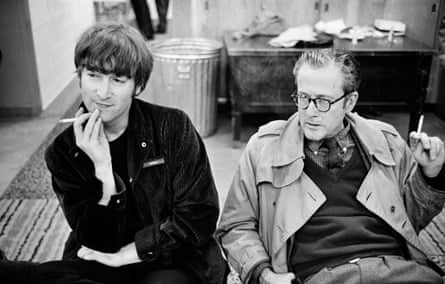 Lennon and Gleason sitting next to each othe in the locker room, smoking