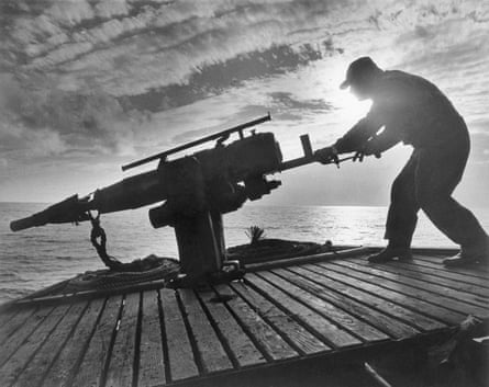 Whaler on deck of ship, silhouetted by sinking sun