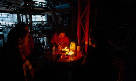 People at a restaurant lit with candles in Lviv, Ukraine, amid a power outage