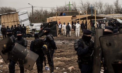 French police stand guard near makeshift places of worship at the migrant camp in Calais.