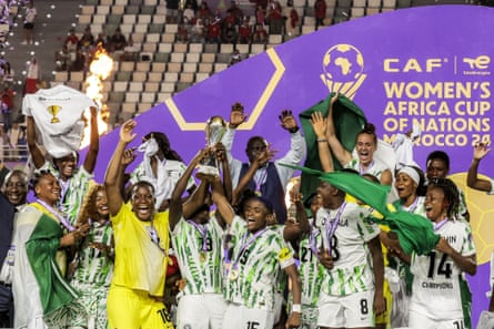 Nigeria’s players celebrate with the trophy on the podium in Rabat
