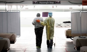 A nurse supports a patient as they walk in the Covid-19 alternative care site, built into a parking garage, at Renown regional medical center, 16 December 2020 in Reno, Nevada.