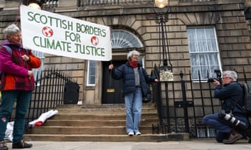 Two women hold a sign saying 'Scottish Borders for climate justice'