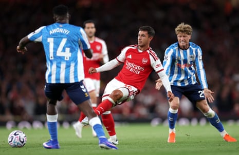 Martin Zubimendi passes the ball under pressure from Taiwo Awoniyi and Victor Torp.