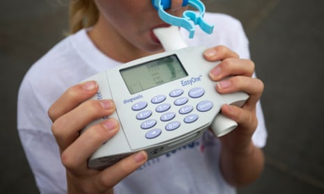 A young girl blows into a spirometer during a photocall to promote clean air in London. 