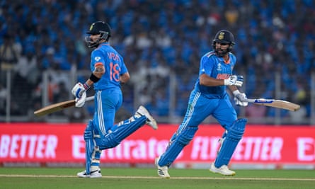 Rohit Sharma and Virat Kohli pass each other while running on the pitch during India’s World Cup victory against Pakistan on 14 October.