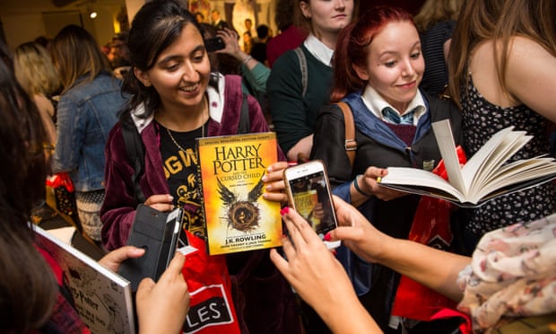 Customers take photos after buying a copy of JK Rowling’s Harry Potter and The Cursed Child at midnight on 31 July, in Foyles bookstore in London.