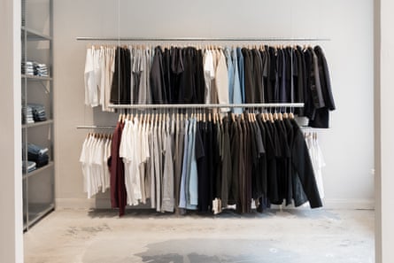 Inside a clothes shop with two suspended clothing racks of garments.