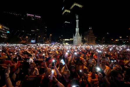 Spain's supporters turn on their phone flashlights as they watch the match on giant screens underneath the Christopher Columbus statue on Plaza de Colon in Madrid.