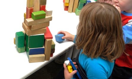 A child playing with colourful toy wooden bricks.