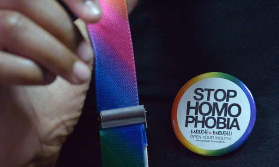 Close-up of unidentified black person wearing rainbow-coloured braces and a badge saying: Stop homophobia