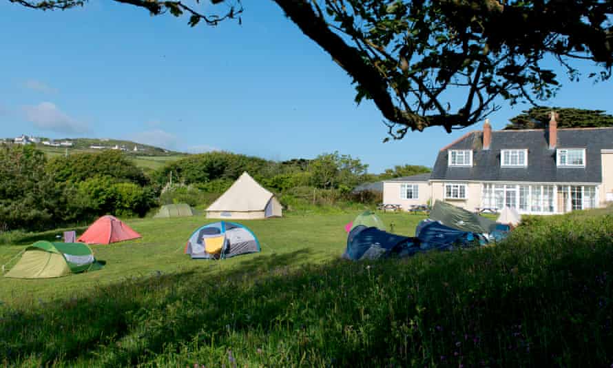 YHA Land's End, imagen exterior del campo, carpas y edificio YHA, Cornwall, Reino Unido.