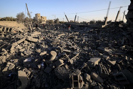 People walk on the rubble of a destroyed building after an Israeli strike in Khan Younis.