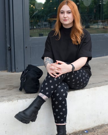 Laura sits on a step with handbag next to her