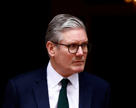 Keir Starmer outside No 10, wearing a dark jacket and tie, looking sombre.