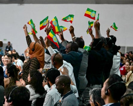A group of people stood waving the Ethiopian flag.
