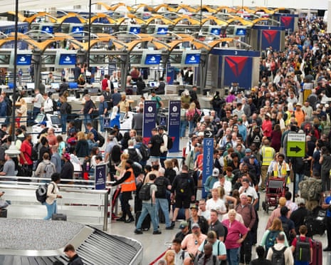 Travelers stand in long lines at Atlanta Hartsfield-Jackson International Airport on Sunday.
