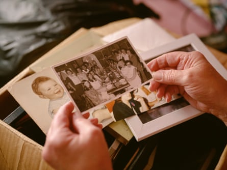 Ellen Rogers holds a stack of photos, some in black and white