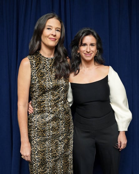 Two women in evening dress standing in front of a sky midnight blue curtain
