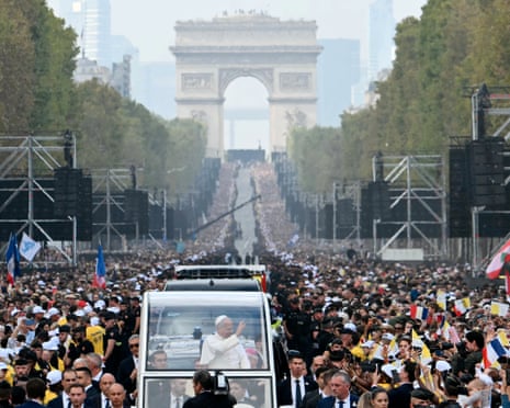 Pope Leo XIV waves to the crowd from the Papamobile as he rides down the Champs-Elysees Avenue on his way to the Place de la Concorde, central Paris.