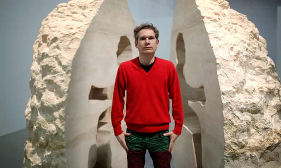 French artist Abraham Poincheval poses in front of his artwork Pierre in Paris.