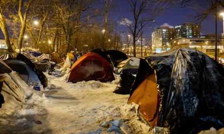 People sleep in tents near a wooded area adjacent to an expressway in Chicago in 2019.