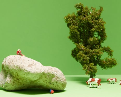 image of tiny man sitting on a rock