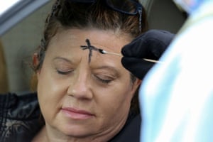 A woman receives ashes at the drive-through service in Metairie
