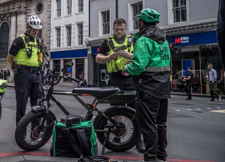 ‘This is basically a motorcycle’ … PC David Parker (left) and PC Harry Rose stop delivery rider Mahede Hasan for riding an illegal e-bike in the City of London.