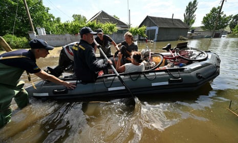 Rescuers of the Ukrainian State Emergency Service evacuate local residents from a flooded village in Kherson, Ukraine.