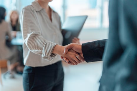Business people shaking hands in a modern office.