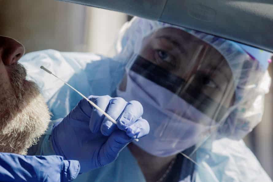 Nurse Theresa Malijan administers a test for coronavirus disease (COVID-19) to a patient at a drive-through testing site in a parking lot at the University of Washington’s Northwest Outpatient Medical Center, during the coronavirus disease (COVID-19) outbreak, in Seattle, Washington, U.S. March 18, 2020.