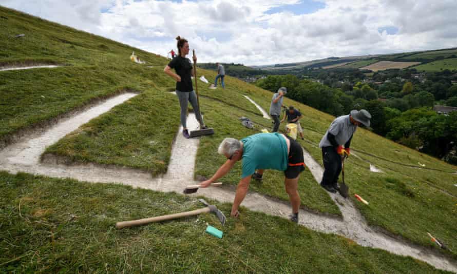Volunteers rechalking the Cerne Giant’s ribs