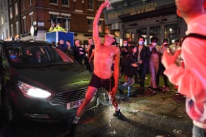 A man pours water over himself in Soho after lockdown restrictions on pubs and restaurants are eased in England