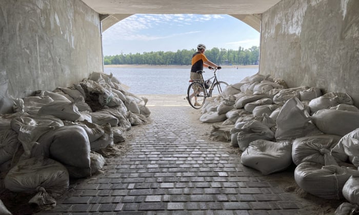 Russia-Ukraine war live news: 10 killed in strike on Donetsk apartment block; Zelenskiy dismisses ambassadors | Ukraine 4 A cyclist emerges from a sandbagged tunnel next to the Dnipro River in Kyiv, Ukraine on Sunday. (AP Photo/Cara Anna)
