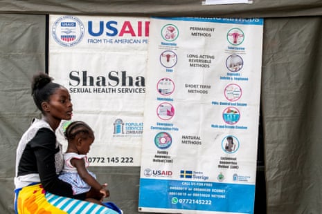 a woman sits with a child at a clinic