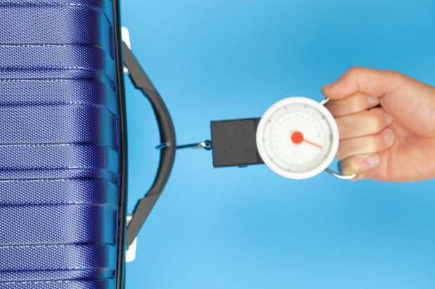 A hanging hook scale weighing a piece of luggage.