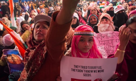 Women protesting in Shaheen Bagh, one holding sign reading: 'They tried to bury us. They didn't know we were seeds.'
