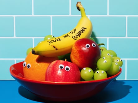 A fruit bowl with apples, an orange and grapes, all with googly eyes on them, and a banana on top with ‘you’re my top banana’ written on it in thick black pen