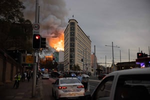 A view down Elizabeth St in Sydney's CBD showing the fire blazing behind the Sydney dental hospital and smoke billowing into the sky