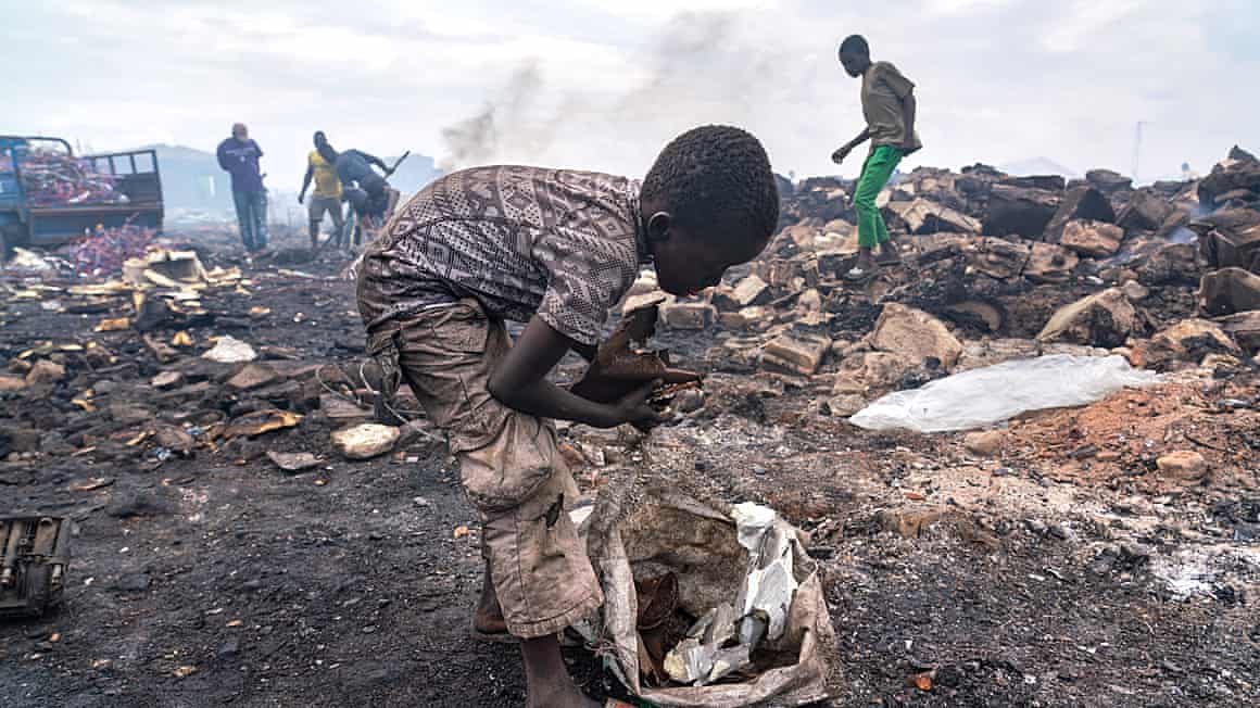 A boy sifts through rubbish on a waste site